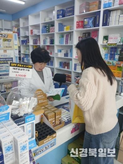 남구 치매안심약국 약사가 치매안심센터 직원의 설명을 듣고 있는 모습